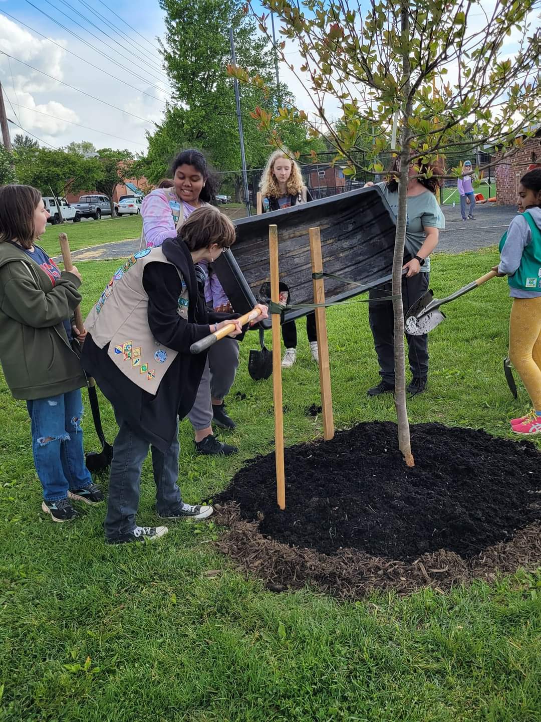 Picture of girl scouts helping to plant a tree at the Arbor Day Tree Ceremony in April 2023. 