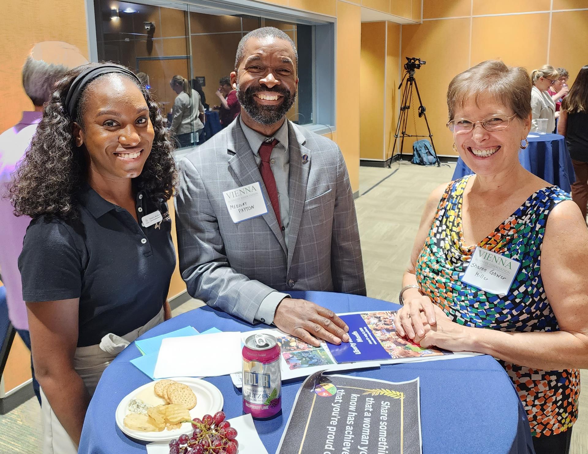 Photo of three people smiling at panel event.